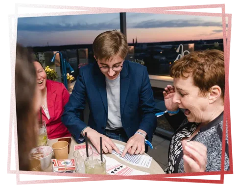 Eine Gruppe von Menschen sitzt an einem Tisch, während sie Spaß haben und lachen.
